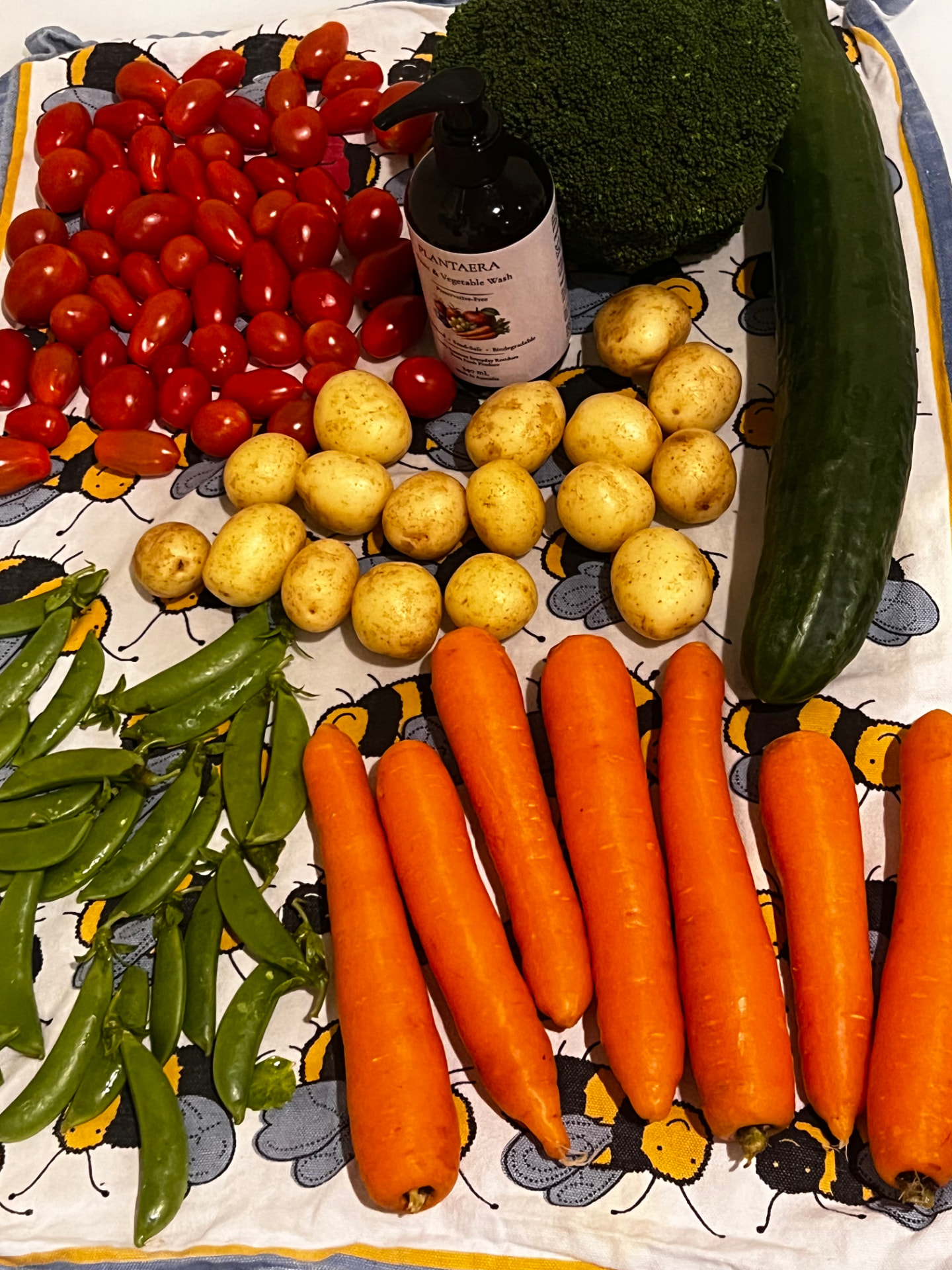 Freshly washed produce arranged on a kitchen counter with a Plantaera bottle