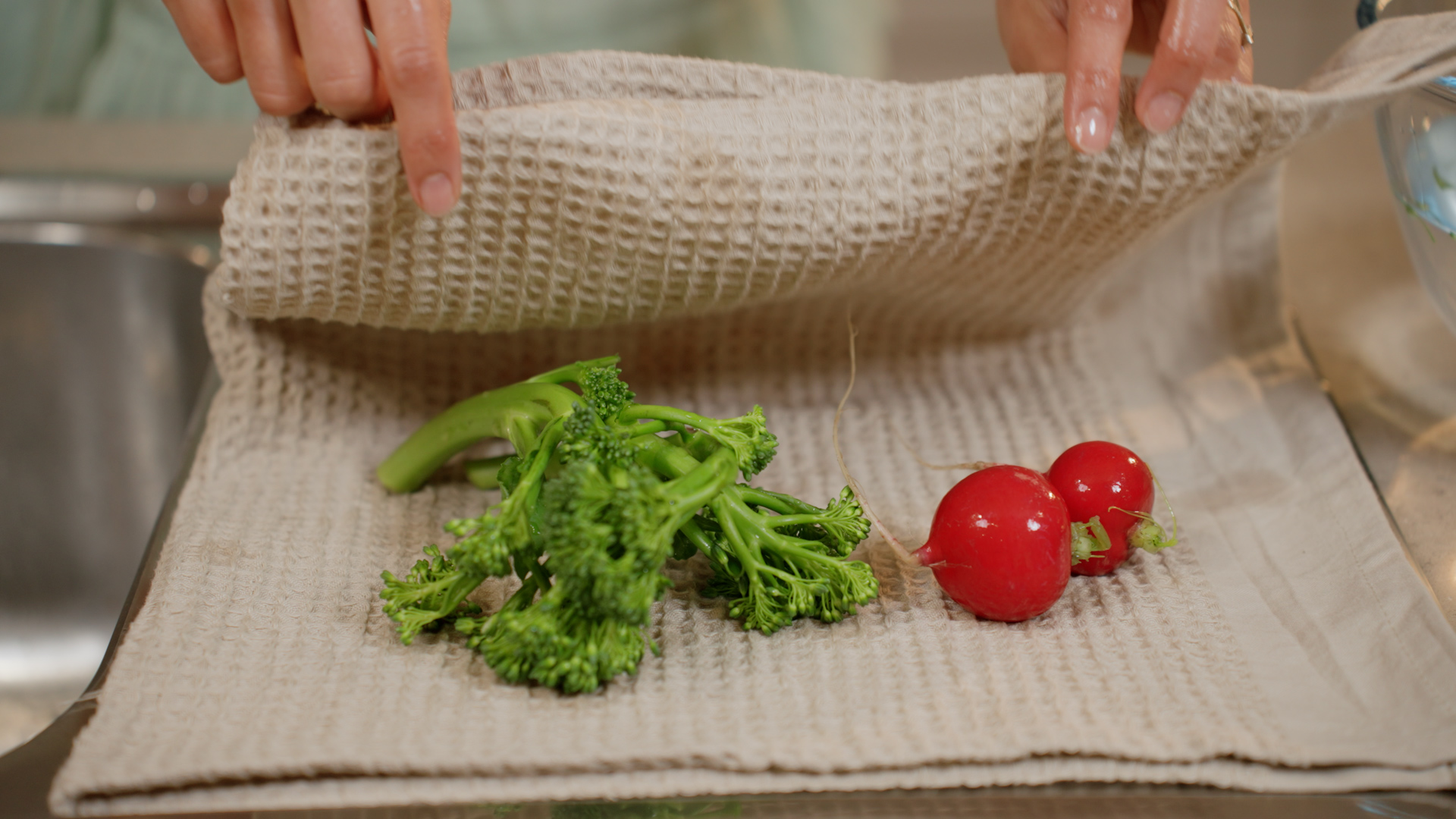 A red radish drying on linen beside the sink